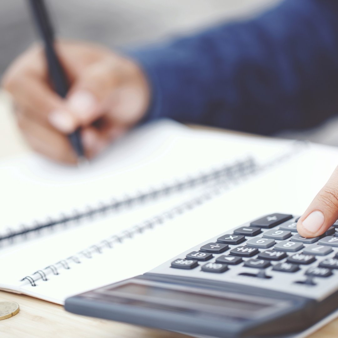 notepad and calculator with person in background